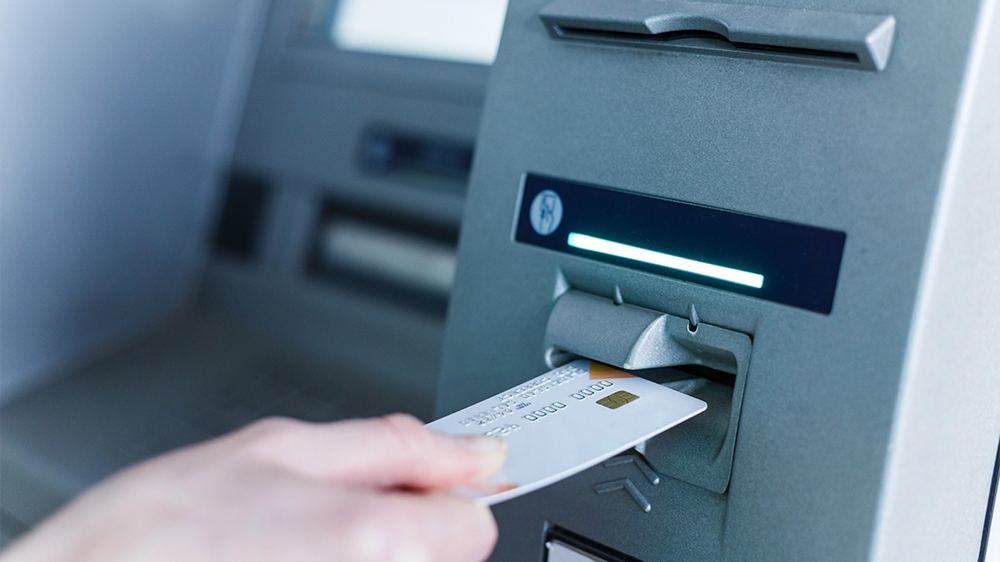 Person insert card to automated teller machine