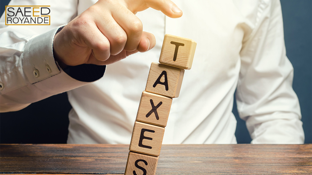 Businessman removes wooden blocks with the word tax