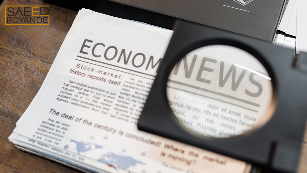 Magnifying glass over newspapers with economic news