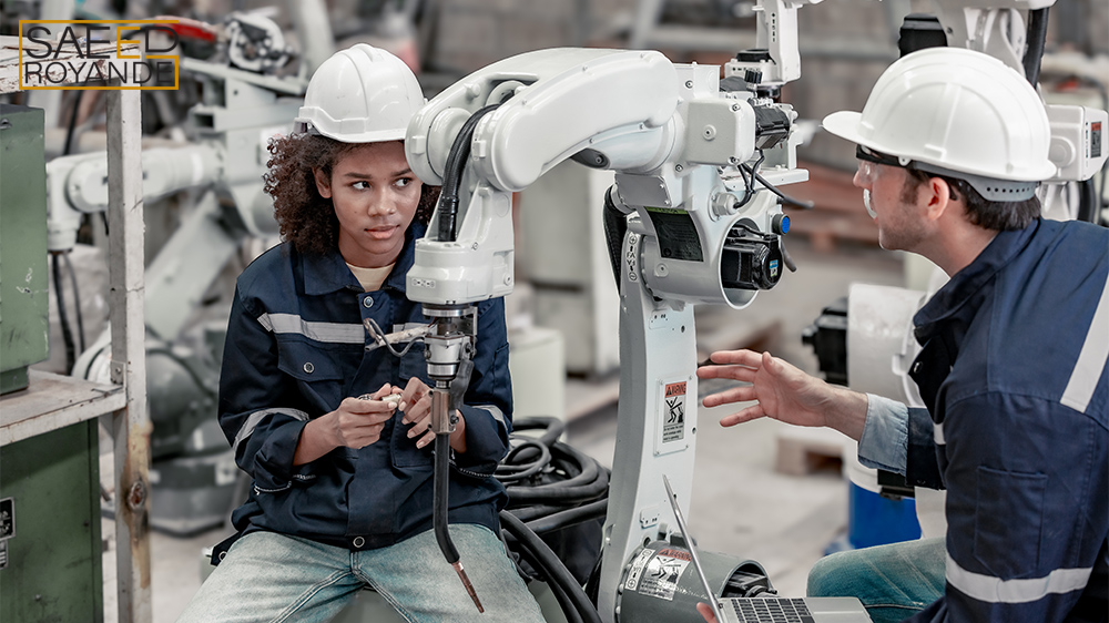 Robotics supervisor mentors trainee in automation